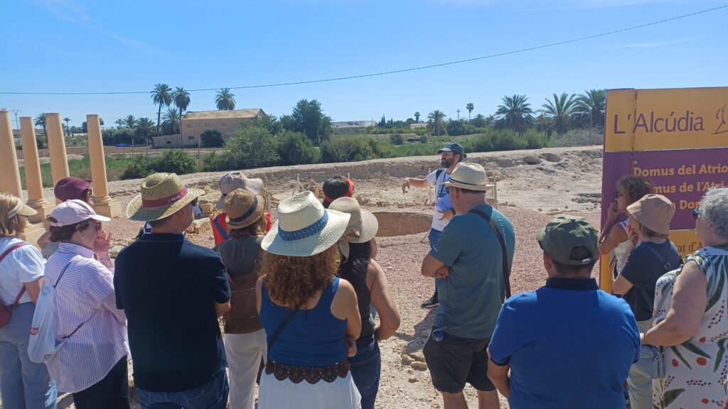 Grupo de visitantes escucha a un guía a la entrada de La Alcudia