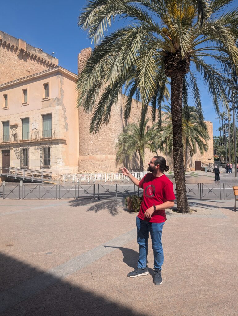 Una guía explica junto al palacio de Altamira y las palmeras
